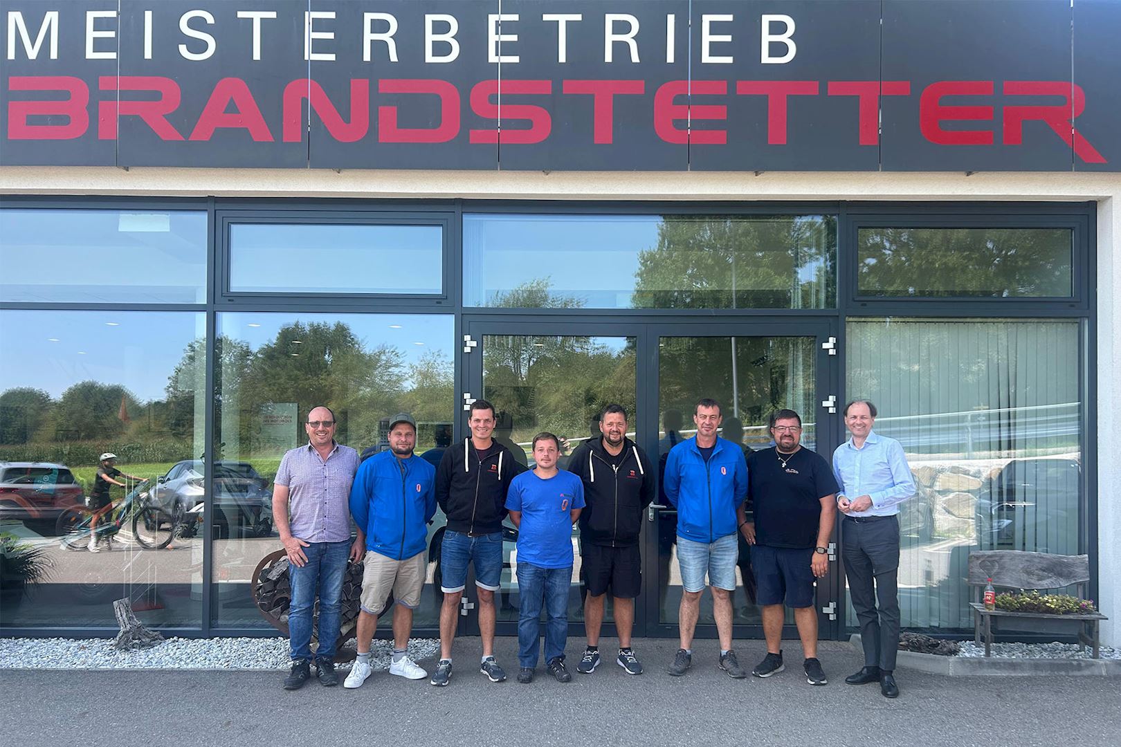 WIFI-Trainer Herbert Diernegger (1.v.l.) und WIFI NÖ-Produktmanager Martin Nowak (1.v.r.) gratulierten den erfolgreichen Teilnehmern. (Foto: KFZ-Brandstetter) Teilnehmer vor einem Gebäude